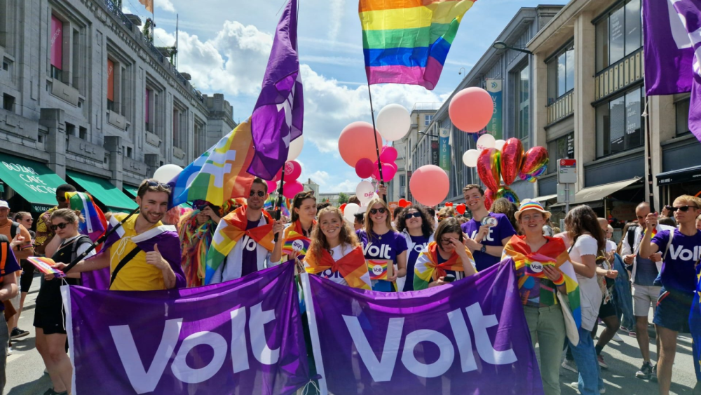 Volters wearing and holding rainbow flags and Volt flags at a Pride march