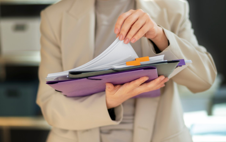 a person holding various kinds of documents