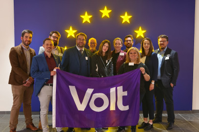 Group of Volters holding a Volt flag in front of European stars